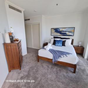 a bedroom with a large bed with blue pillows at Lux Sub-Penthouse with Casino views in Brisbane
