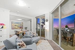 a living room with a couch and a table at Lux Sub-Penthouse with Casino views in Brisbane