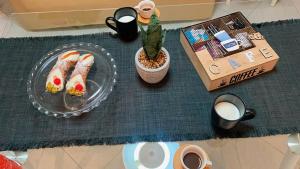 a table topped with a plate of sushi and coffee at Montalbano House - Casa Vacanze in Santa Margherita di Belice