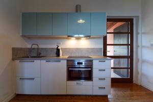 a kitchen with white appliances and blue cabinets at Duca House in San Giovanni