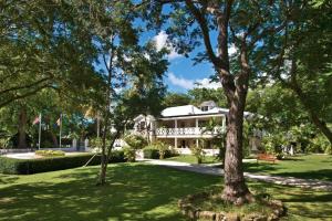 uma casa no meio de um parque com árvores em La Hacienda Bellevue em Bridgetown