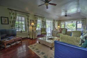 a living room with a couch and a tv at La Hacienda Bellevue in Bridgetown