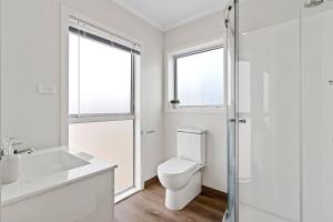 a bathroom with a toilet and a sink and a shower at River City Retreat! King Bed & Central - By KOSH BNB in Hamilton