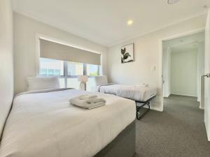 ハミルトンにあるRiver City Retreat! King Bed & Central - By KOSH BNBの白いベッドルーム(ベッド2台、窓付)