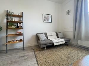 uma sala de estar com um sofá e uma estante de livros em Apartment 2 St Georges em Cheltenham