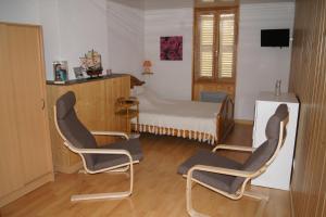 een kamer met 2 stoelen en een bed bij Au P'tit Grillon in Salins-les-Bains