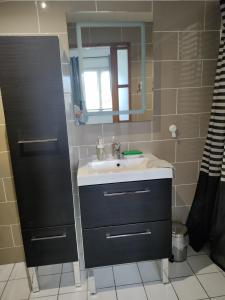 ein Bad mit einem Waschbecken und einem Spiegel in der Unterkunft Chambre d hôte des Abers in Lannilis