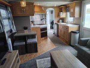 a kitchen and living room with a couch and a table at Sunnyside - Pet friendly, Ingoldmells in Ingoldmells