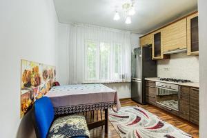 a kitchen with a table and a kitchen with a refrigerator at Maulenova 32.36 kv41 in Almaty