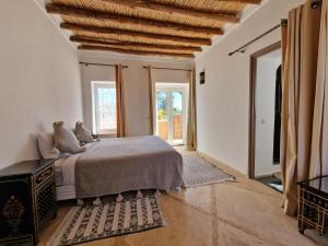 ein Schlafzimmer mit einem Bett und einem großen Fenster in der Unterkunft Manzal Lahbab, 2Villas 2Bungalows 2Piscines et Jardins in Marrakesch