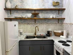 a kitchen with a sink and a white refrigerator at Beachfront Luxury Apartment in Aguada