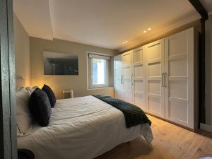 1 dormitorio con 1 cama grande y armarios blancos en La Casita del Mikel, en El Escorial
