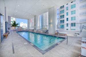 a large swimming pool in a building with windows at Downtown Luxury Studio Pool and Gym in Miami