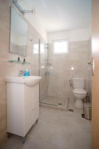 bagno con doccia, lavandino e servizi igienici di Karnagio Rooms a Kyparissia