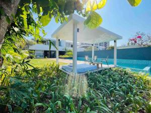 達波林的住宿－Sea View Luxury Villa with 2 Swimming Pools，池畔凉亭配有桌椅