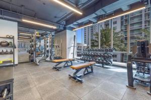 une salle de sport avec des tapis de course et des bancs dans un bâtiment dans l'établissement Ocean View Cozy Studio Pool and Gym, à Miami