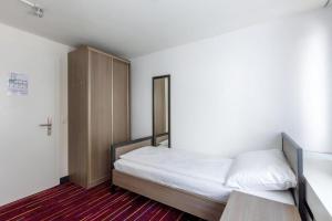 ein kleines Schlafzimmer mit einem Bett und einem Schrank in der Unterkunft Union Light - Self Check-In Hotel in Luzern