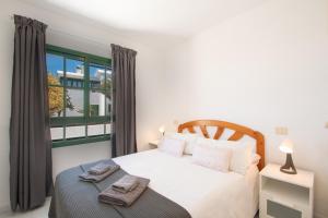 a bedroom with a bed and a large window at CASA PAZ - COZY 2 BEDROOM APARTMENT CLOSE TO DORADA BEACH in Playa Blanca