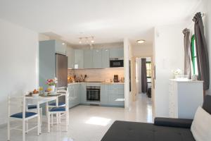 a kitchen with blue cabinets and a table and chairs at CASA PAZ - COZY 2 BEDROOM APARTMENT CLOSE TO DORADA BEACH in Playa Blanca