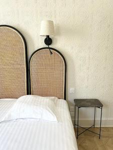 a bedroom with a bed and a lamp and a stool at Hôtel La Tour Intendance in Bordeaux