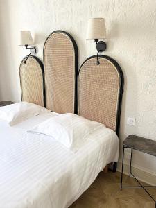 ボルドーにあるHôtel La Tour Intendanceのベッドルーム1室(ベッド1台、ヘッドボード2つ、テーブル付)