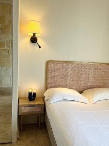 a bedroom with a bed with a lamp and a side table at Hôtel La Tour Intendance in Bordeaux