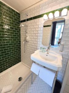 W łazience znajduje się umywalka, lustro i wanna. w obiekcie Hôtel La Tour Intendance w mieście Bordeaux