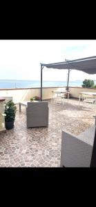 een patio met tafels en stoelen en een parasol bij B&B I 3 Mori in Barcellona-Pozzo di Gotto