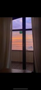 uma vista para o oceano a partir de uma janela com cortinas em B&B I 3 Mori em Barcellona-Pozzo di Gotto