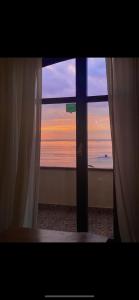 a view of the ocean from a window with curtains at B&B I 3 Mori in Barcellona-Pozzo di Gotto