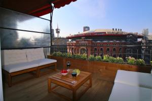 uma varanda com um sofá, uma mesa e um edifício em Beautiful apartment in the center equipped for 7 em Barcelona