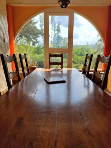 mesa de comedor con sillas y ventana grande en Nature, espace et confort, 