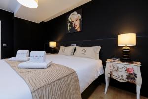 a bedroom with a bed and a table with lamps at The Queen Luxury Apartments - Villa Marilyn in Luxembourg