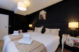 two beds in a room with black walls at The Queen Luxury Apartments - Villa Marilyn in Luxembourg