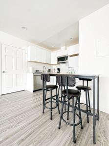 a kitchen with white cabinets and a table and stools at Cozy Guesthouse in LA (WO2 - BUR) in Burbank