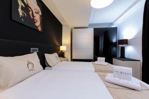 a bedroom with a white bed and a black wall at The Queen Luxury Apartments - Villa Marilyn in Luxembourg