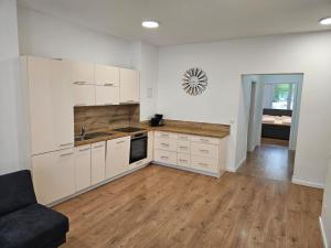 a kitchen with white cabinets and a wooden floor at GardenLoft no2 in Vienna
