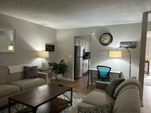 uma sala de estar com um sofá e um relógio na parede em Mar town house em Smyrna