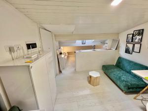 ein kleines Wohnzimmer mit einer grünen Couch und einer Küche in der Unterkunft Un Piccolo Rifugio nel Borgo in Bergamo