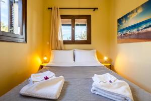 a bedroom with a bed with towels on it at Stoupa Serene Nests - Spitiko Getaway in Stoupa