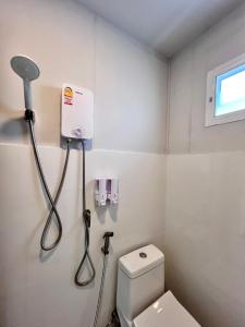 a small bathroom with a toilet and a shower at MrT Riverside Sampran มิสเตอร์ที โฮมสเตย์-ทองกวาว in Sam Phran