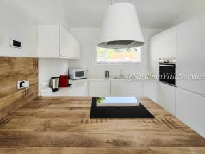 uma cozinha com armários brancos e piso em madeira em Villa Lilium em Cannigione
