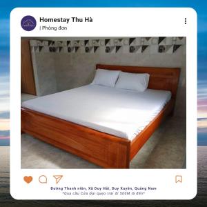 een bed met witte lakens en een houten frame bij Homestay Thu Hà in Duy Xuyên