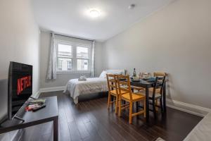 een kamer met een bed en een tafel en stoelen bij Serenity by the Falls - Modern 2 Bedroom Hideaway in Niagara Falls
