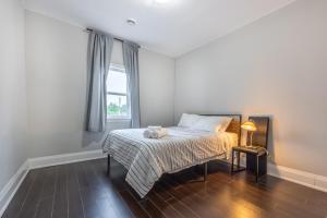 a bedroom with a bed and a window at Serenity by the Falls - Modern 2 Bedroom Hideaway in Niagara Falls