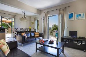 a living room with a couch and a table at Villa Lourdas Beach by Villa Plus in Trápeza