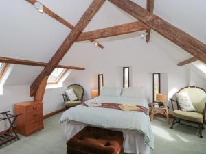 una camera con un letto e due sedie di Higher Putham Barn a Wheddon Cross