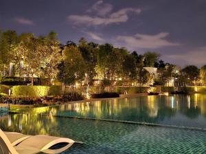 a pool of water at night with a white chair at NEW Elegant & Cozy Greenfield Home near Sunway 2-6pax in Petaling Jaya