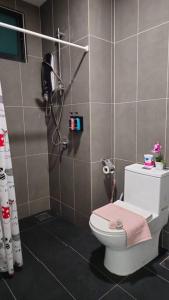 a bathroom with a shower and a toilet with a pink towel at NEW Elegant & Cozy Greenfield Home near Sunway 2-6pax in Petaling Jaya
