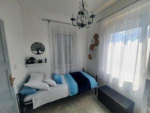 a bedroom with a bed with a chandelier and a window at Apartments Villa Roza in Dražice